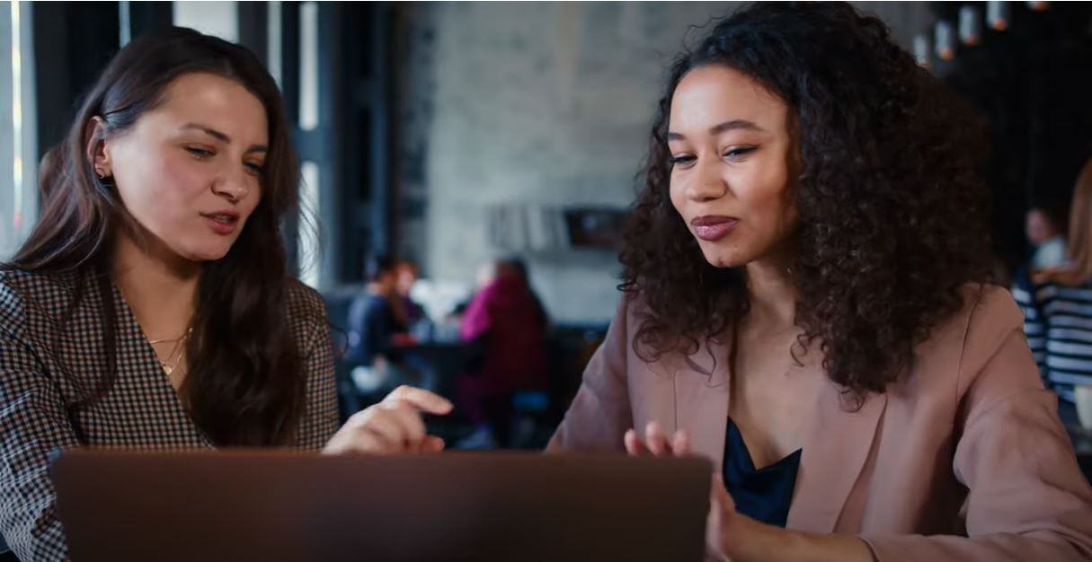 Two women conversing using computer