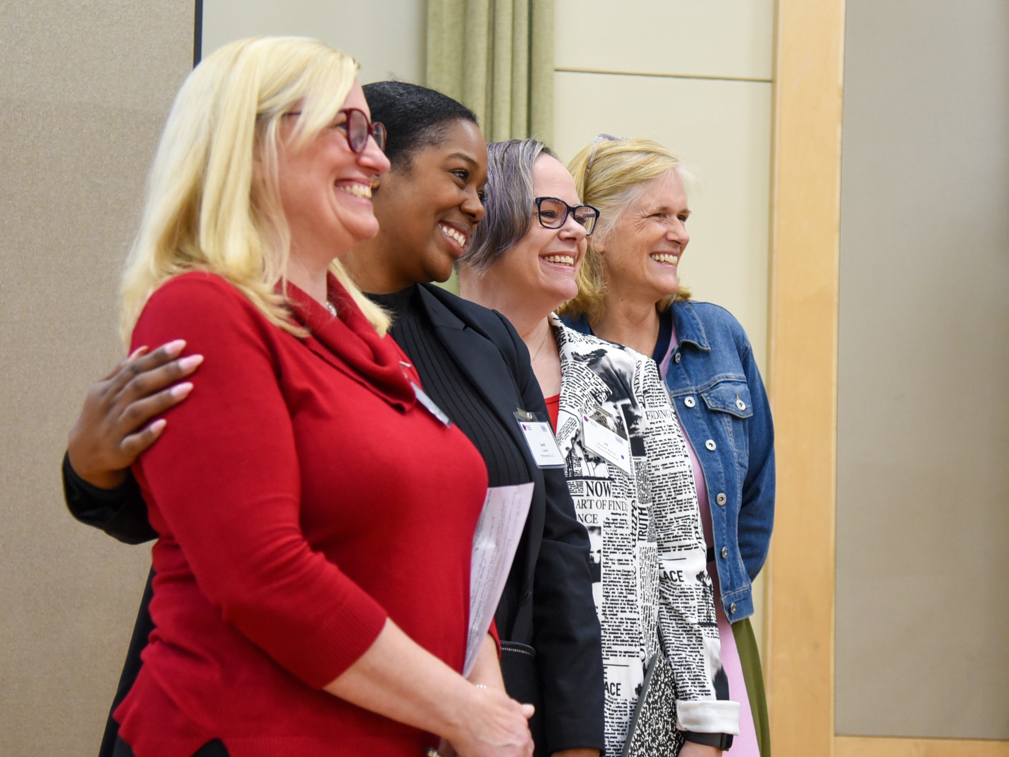 4 women standing together smiling